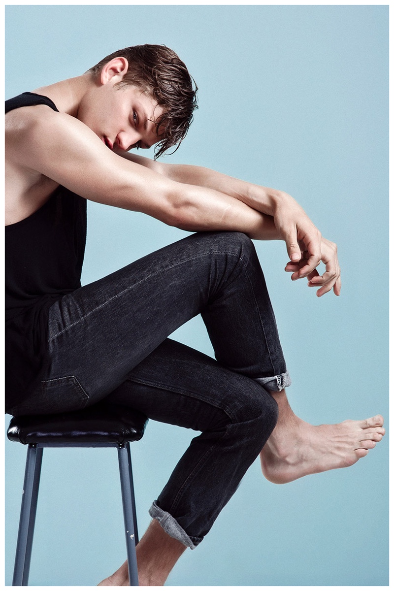 Going for a classic look, a barefoot Sebastian Sauve rocks a pair of skinny denim jeans with a black tank.