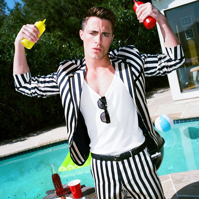 Colton Haynes pictured poolside for a photo shoot in which he wears a striped black and white suit from Gucci's spring-summer 2015 menswear collection.
