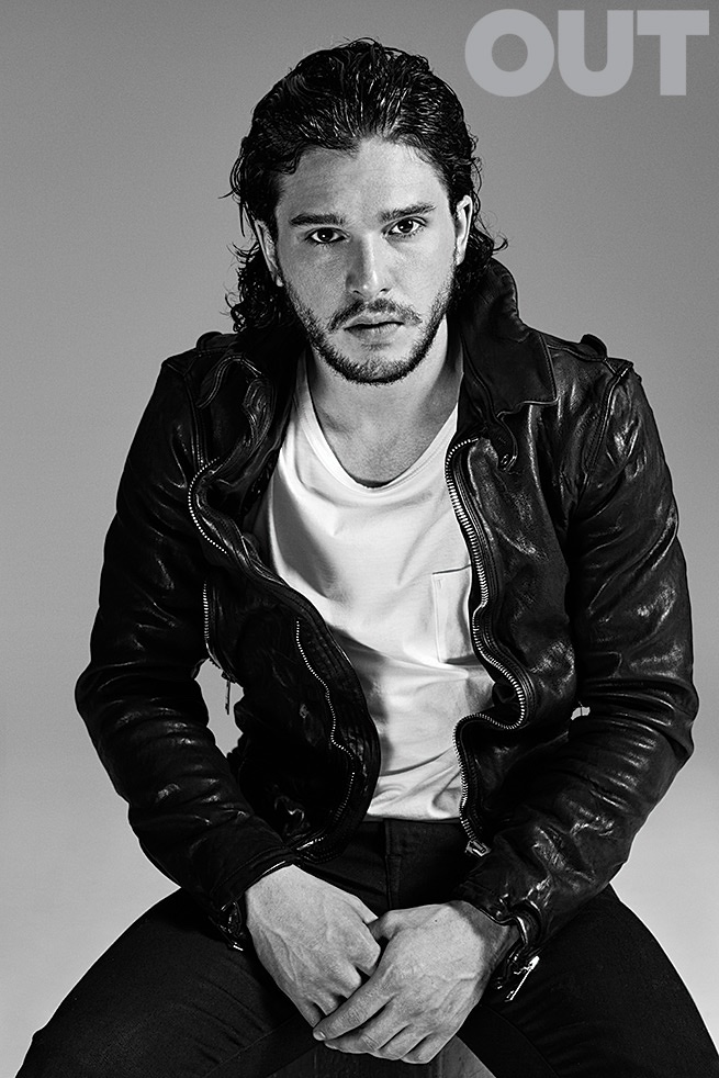 Kit wears a leather jacket and white tee