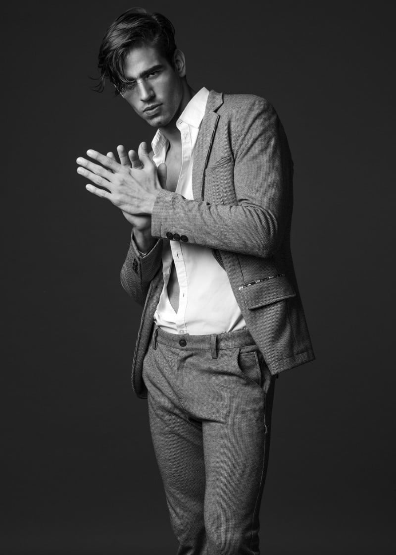 Luis dons a tailored gray suit.
