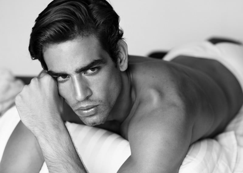 Luis poses for a picture in bed.