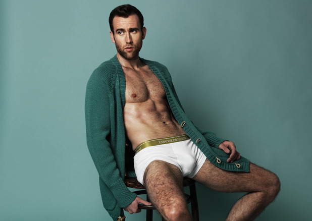 A shirtless Matthew Lewis poses in an oversized cardigan sweater and Emporio Armani underwear.