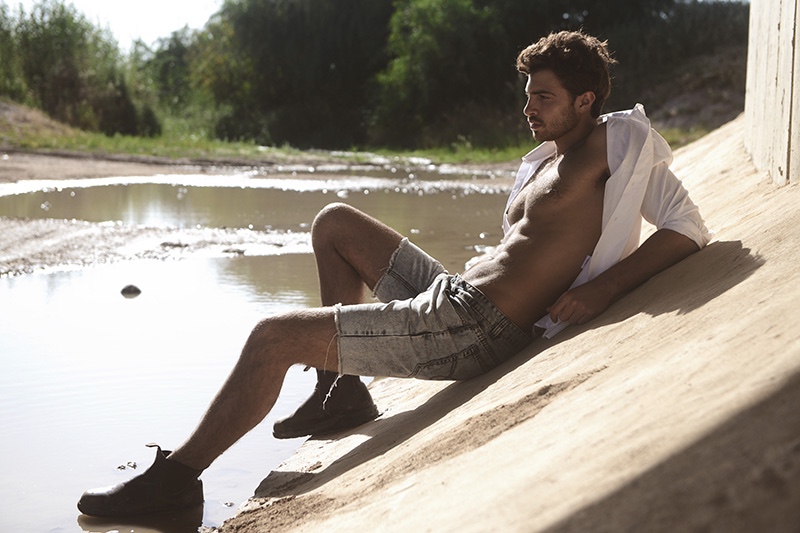 Michael relaxes outdoors in a pair of denim shorts with an open white shirt.