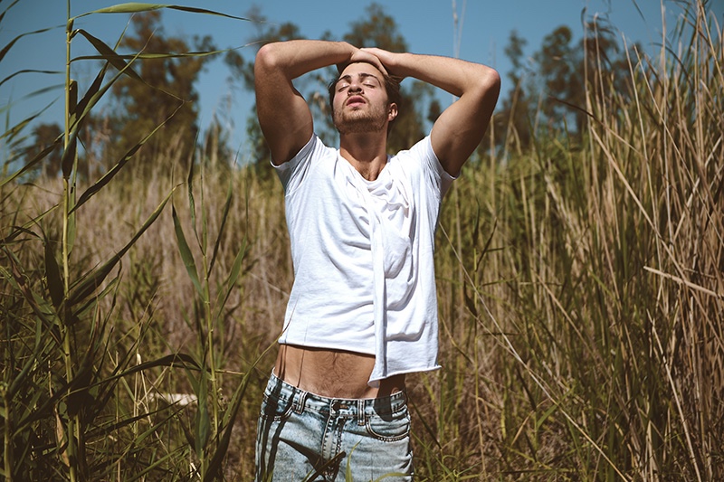 Michael stretches in a draped white shirt.