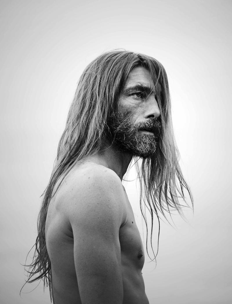 Patrick Petitjean lets his long hair down for a shirtless black & white portrait.