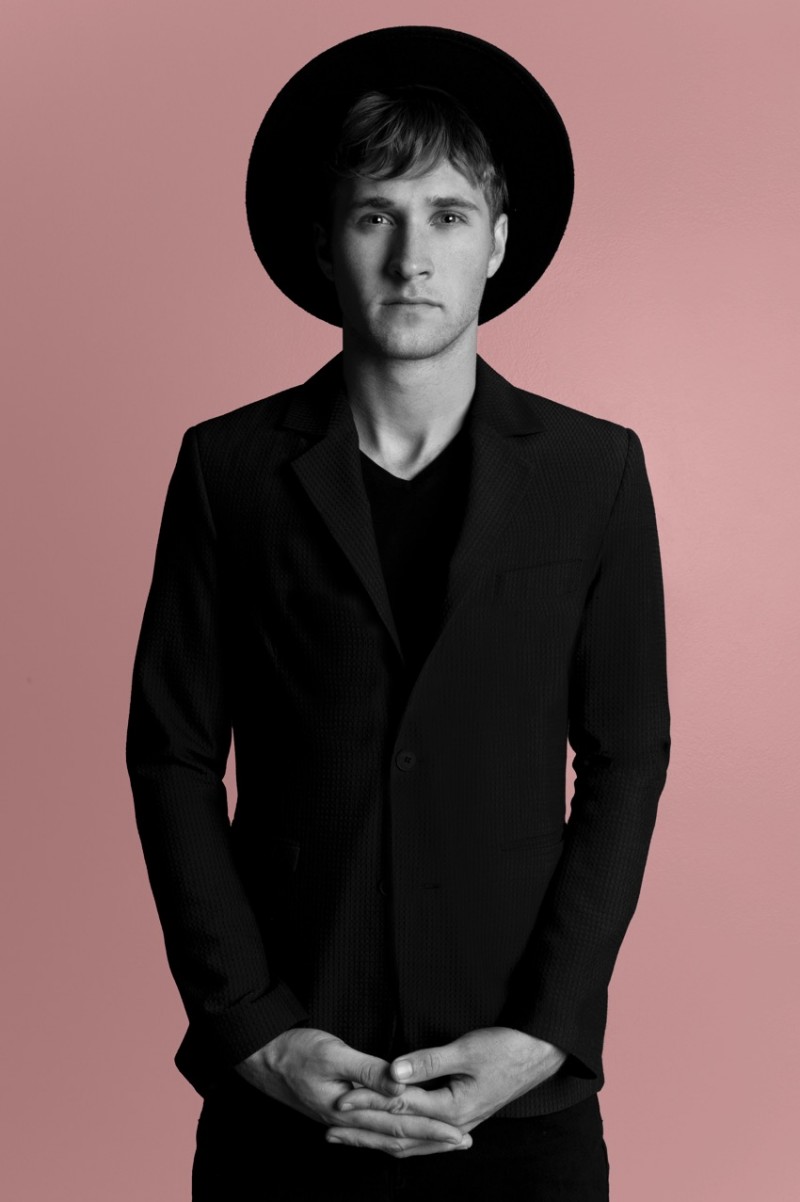 Trevor is a figure in black as he sports a trendy wide brimmed felt hat.