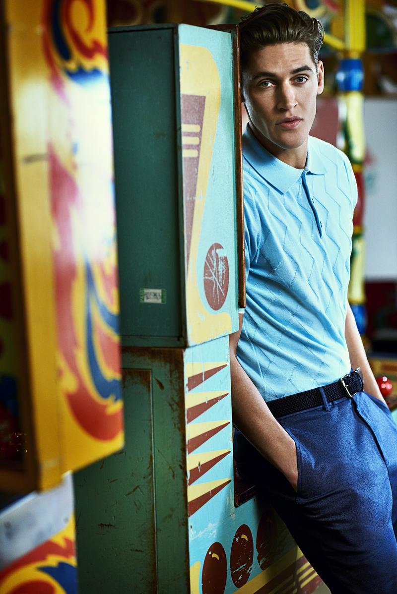 Isaac sports a knitted polo shirt.