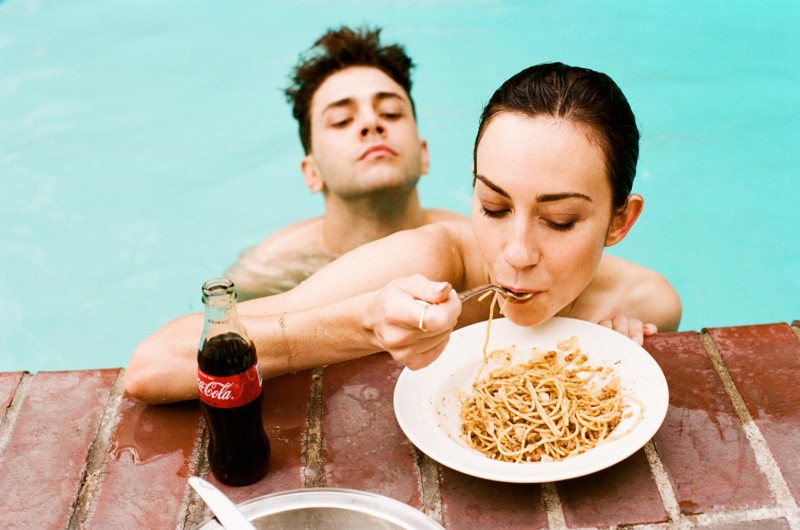 Gia Coppola grabs a bite as Xavier Dolan looks on.