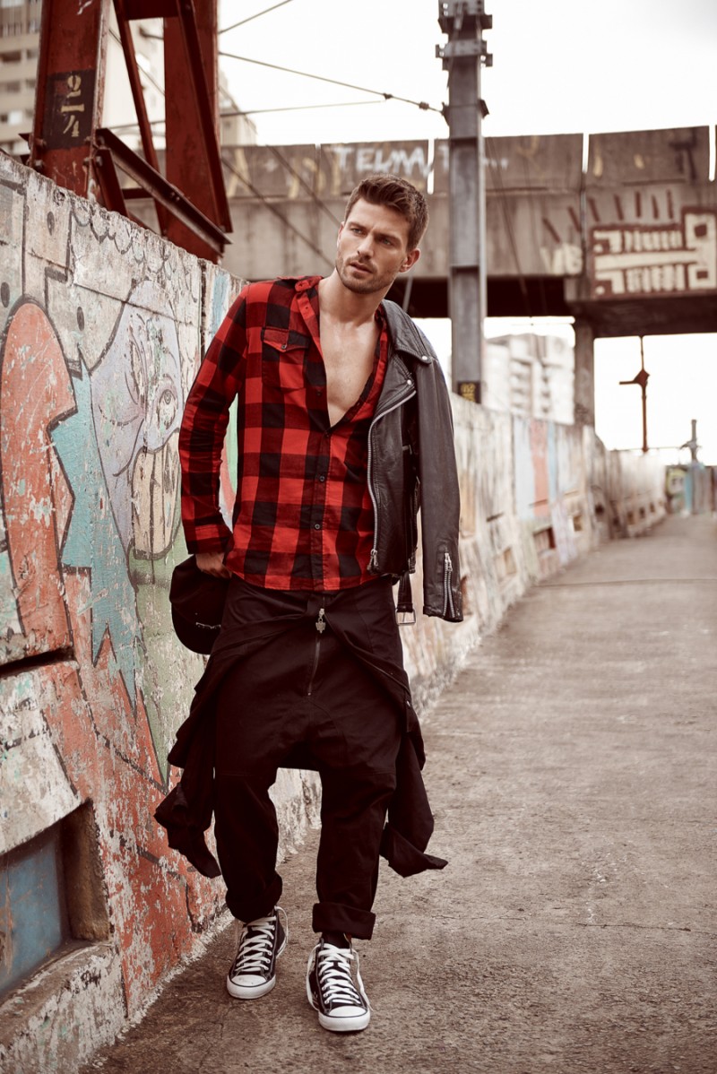 Michael wears buffalo check shirt H&M, leather jacket Diesel and jumpsuit Cavalera.