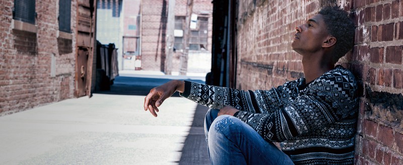 Model Ty Ogunkoya poses in a print knit and denim jeans for Tom Tailor Denim's fall-winter 2015 campaign.
