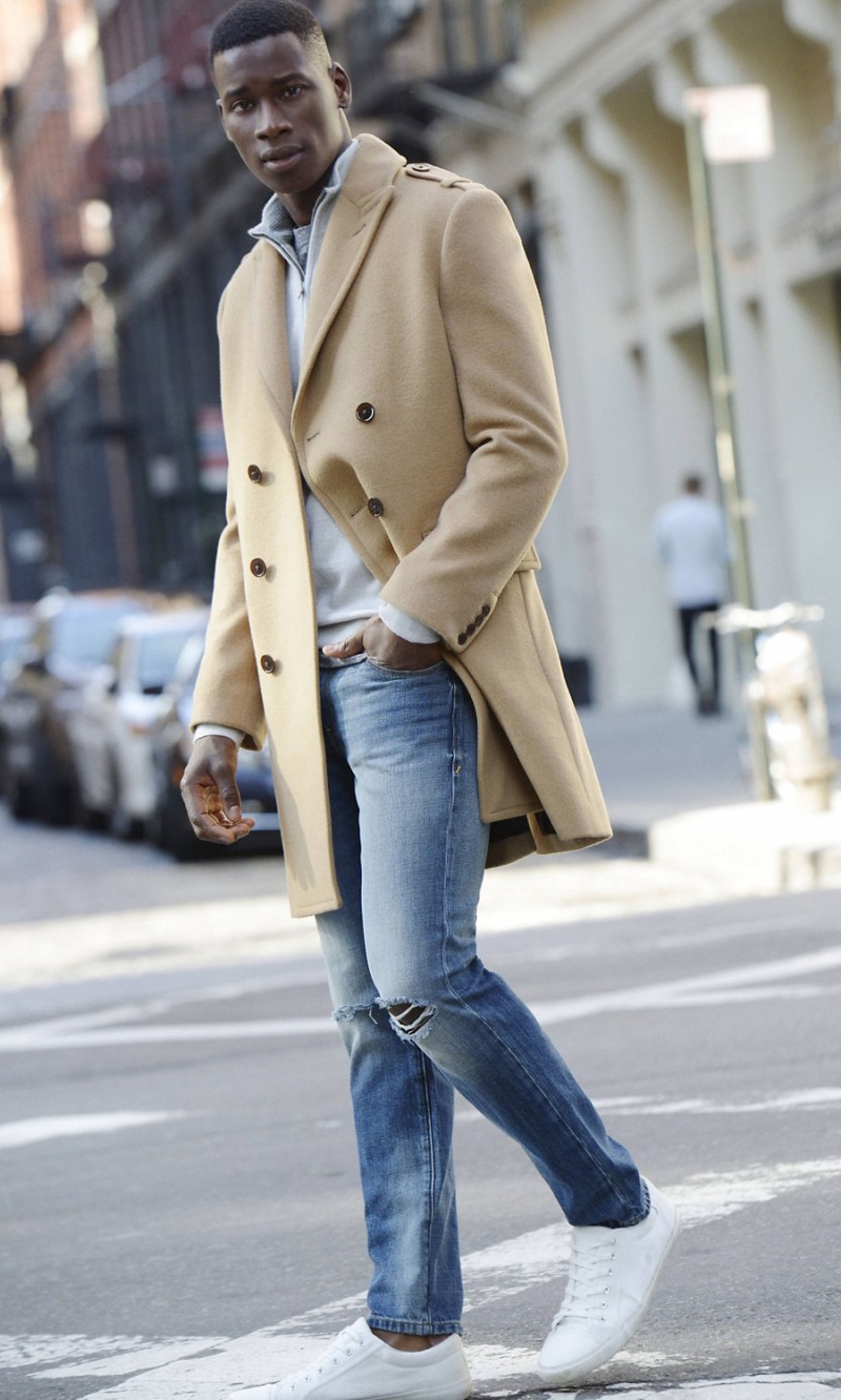 David Agbodji plays it cool in distressed denim jeans and a classic camel coat.
