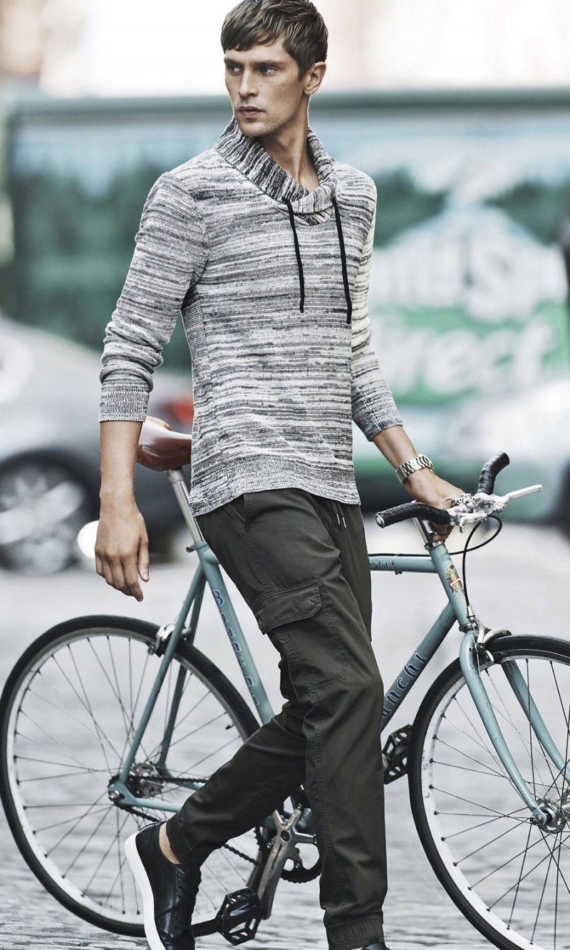Mathias Lauridsen prepares for a bike ride in Express' marle shawl neck pullover sweater with cargo pants.