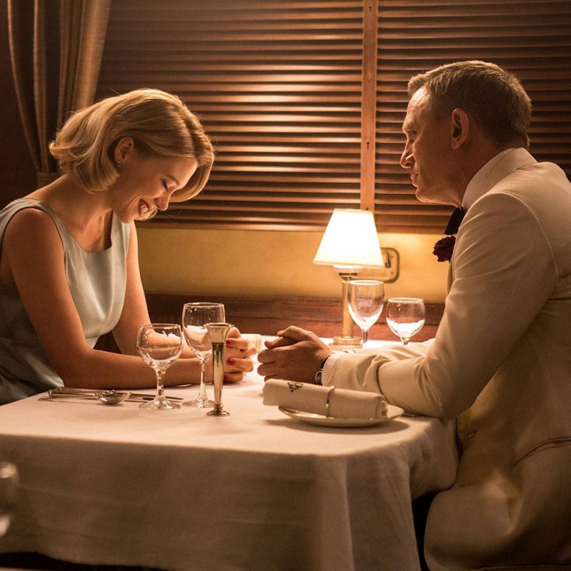 James Bond (Daniel Craig) enjoys dinner in a white smoking jacket from Tom Ford.