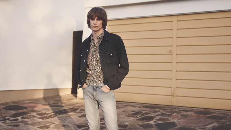 Oscar Robertson wears denim jacket and jeans Acne Studios, leopard print silk shirt and silver curb-link bracelet Saint Laurent.