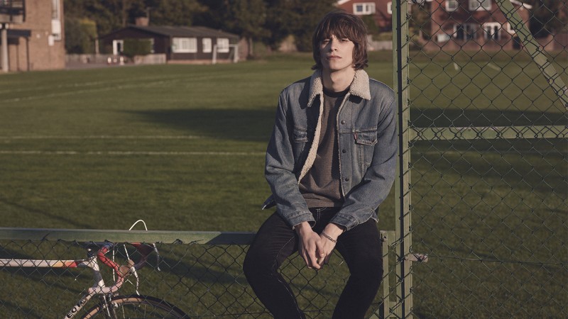 Oscar Robertson wears denim jacket Levi's Vintage Clothing, ponte t-shirt Public School, contrast-stitched corduroy trousers Givenchy and silver curb-link bracelet Saint Laurent.