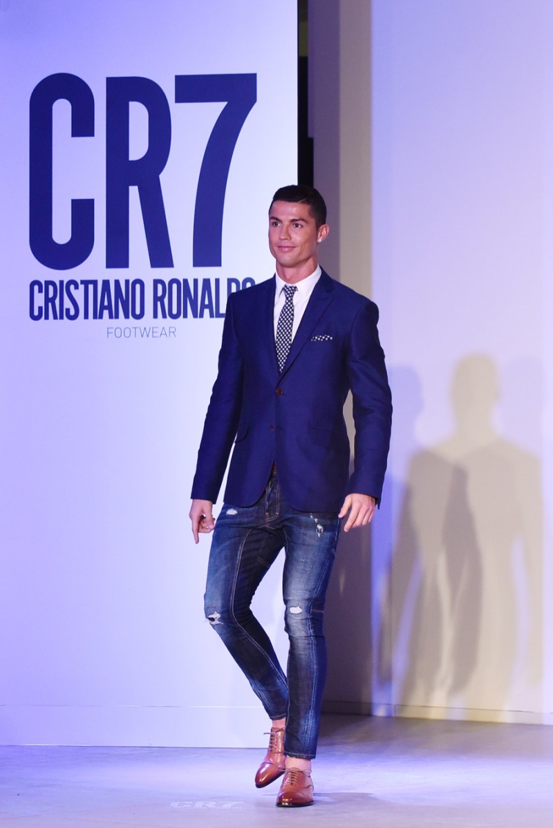 Cristiano Ronaldo hits the catwalk in a smart blazer, shirt and tie, paired with distressed skinny denim jeans and his own footwear.