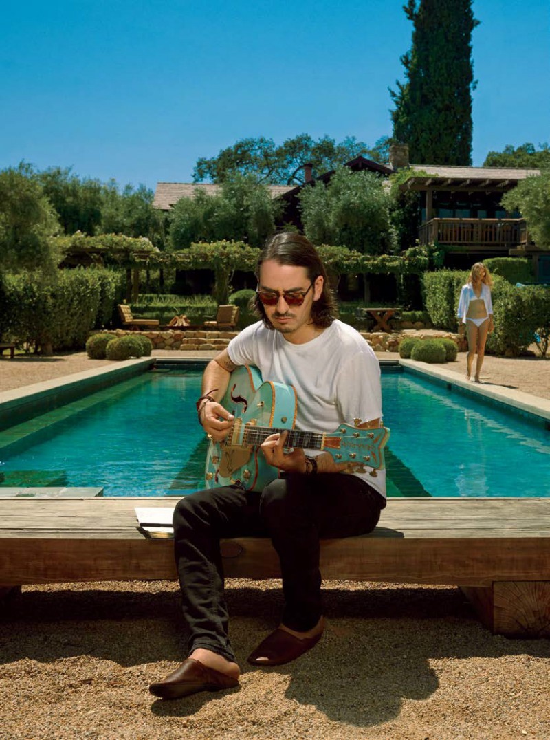 Dhani Harrison relaxes poolside in Oliver Peoples Sheldrake Metal sunglasses.