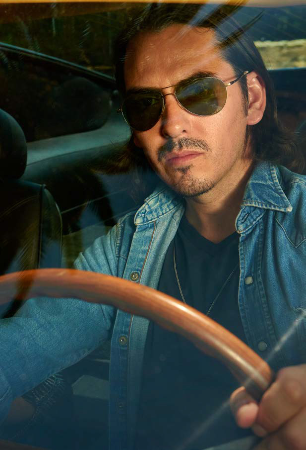 Getting behind the wheel, Dhani Harrison wears Oliver Peoples Kannon aviator sunglasses.