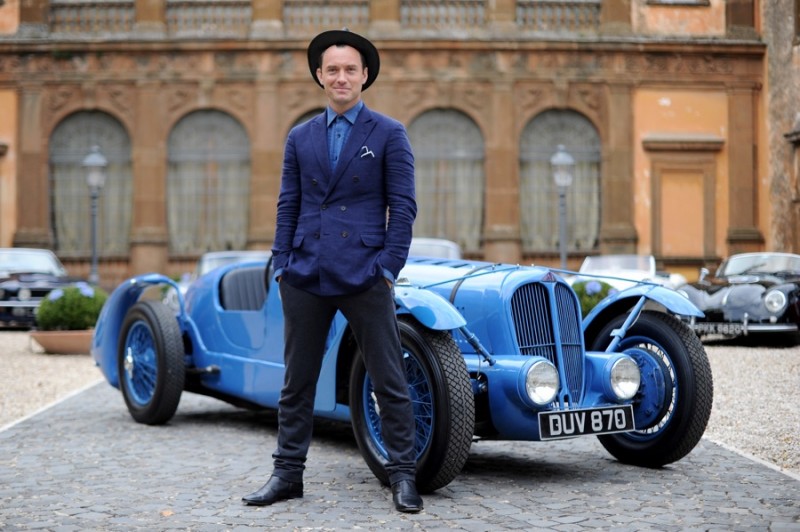 Jude Law charms in smart suiting separates and a stylish fedora.