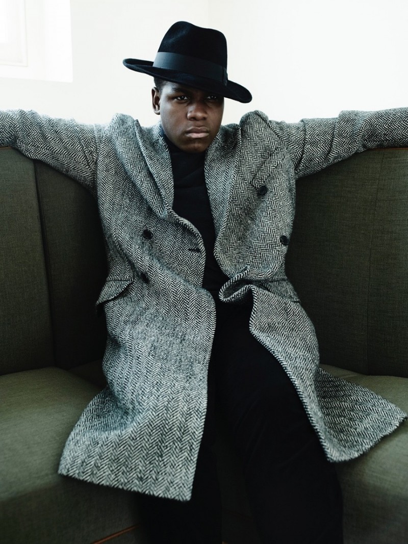 John Boyega relaxes in a double-breasted herringbone coat.