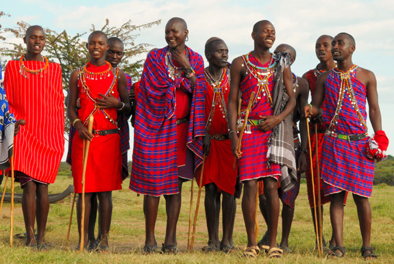 Maasai people pose for a picture in their inspiring red and blue garments. Photo Credit: Wikimedia Commons