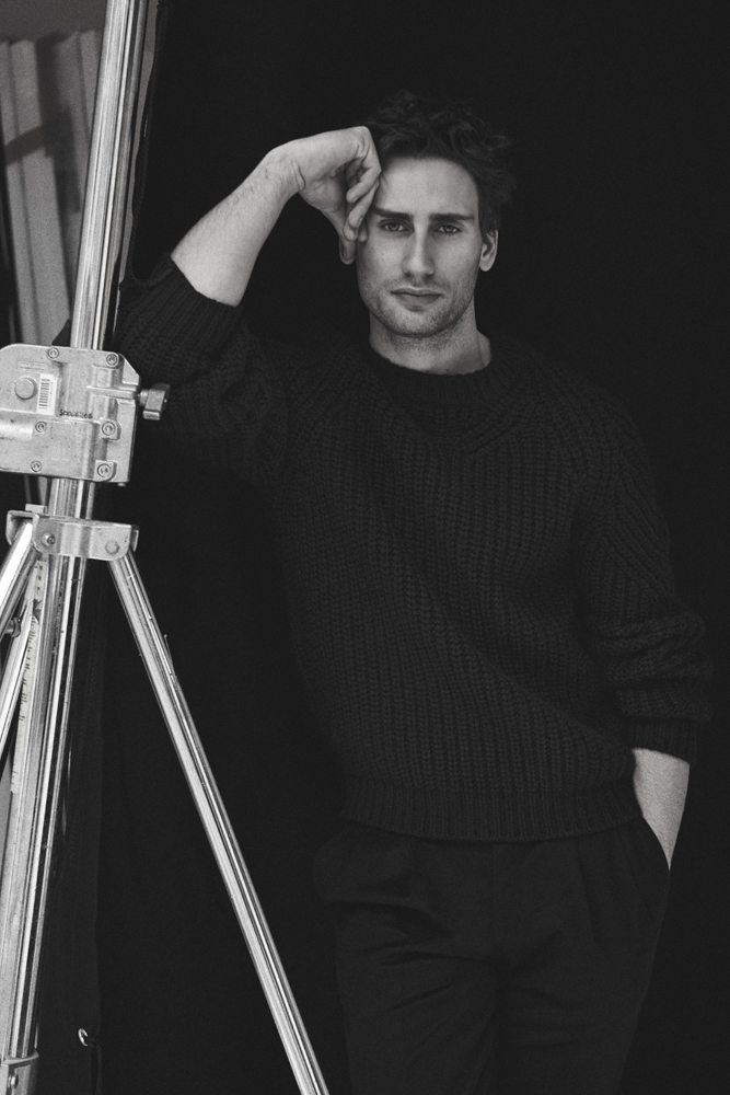 Edward Holcroft poses for Interview magazine in an essential black ensemble from Brioni.
