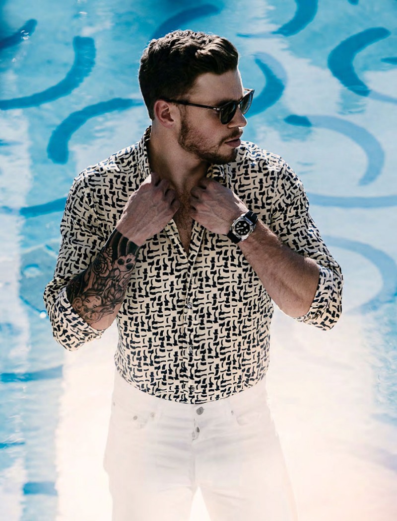 Gus Kenworthy is a cool vision poolside, wearing a Jeffrey Rüdes shirt with white jeans from Sandro and Oliver Peoples sunglasses.