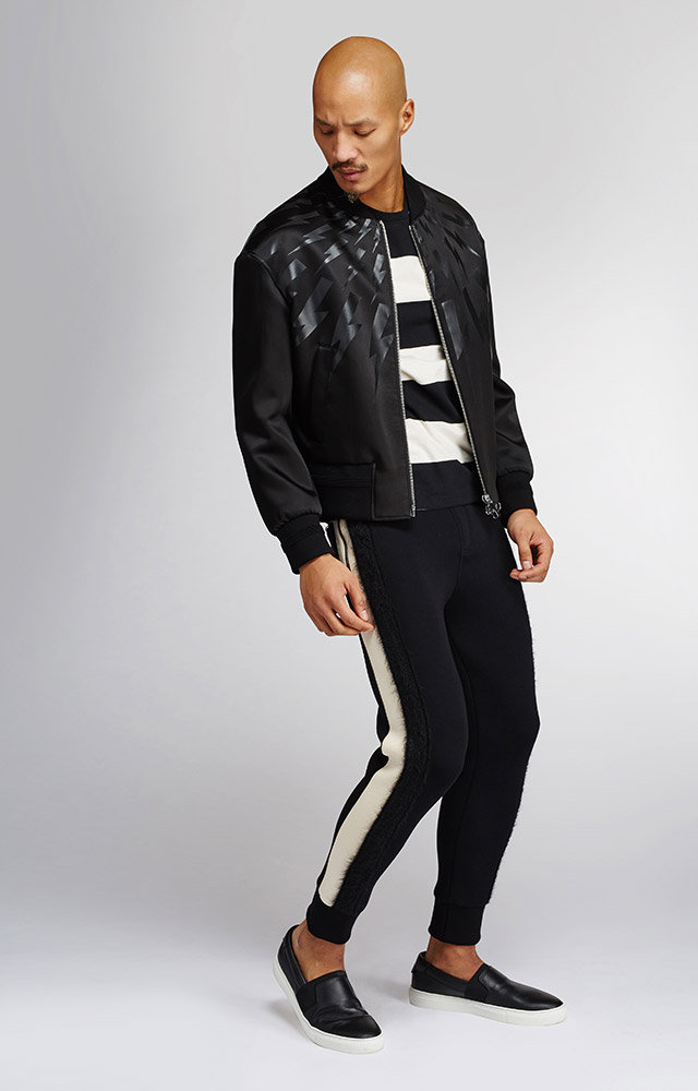 Paolo Roldan wears stripe tee Alexander McQueen, leather slip-on sneakers Balenciaga, lightning bolt bomber jacket and joggers Neil Barrett.