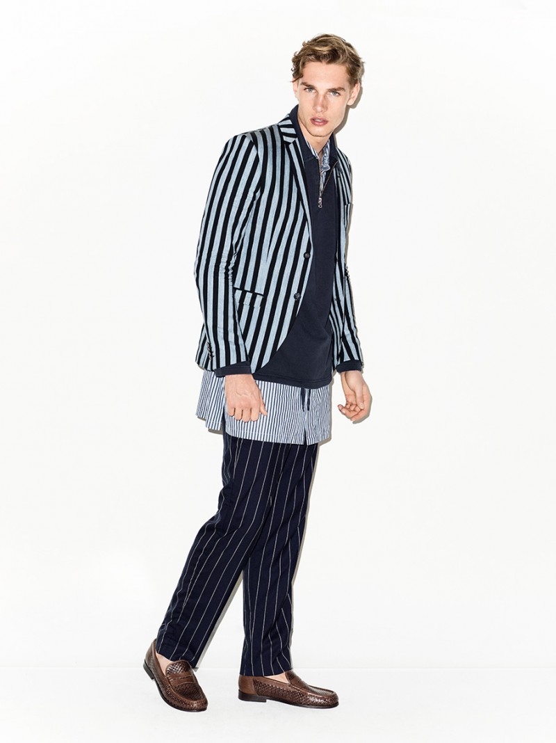 Playing with stripes, Tommy Marr is photographed in a Tiger of Sweden blazer with GANT Rugger trousers and an enlongated shirt from Acne Studios.