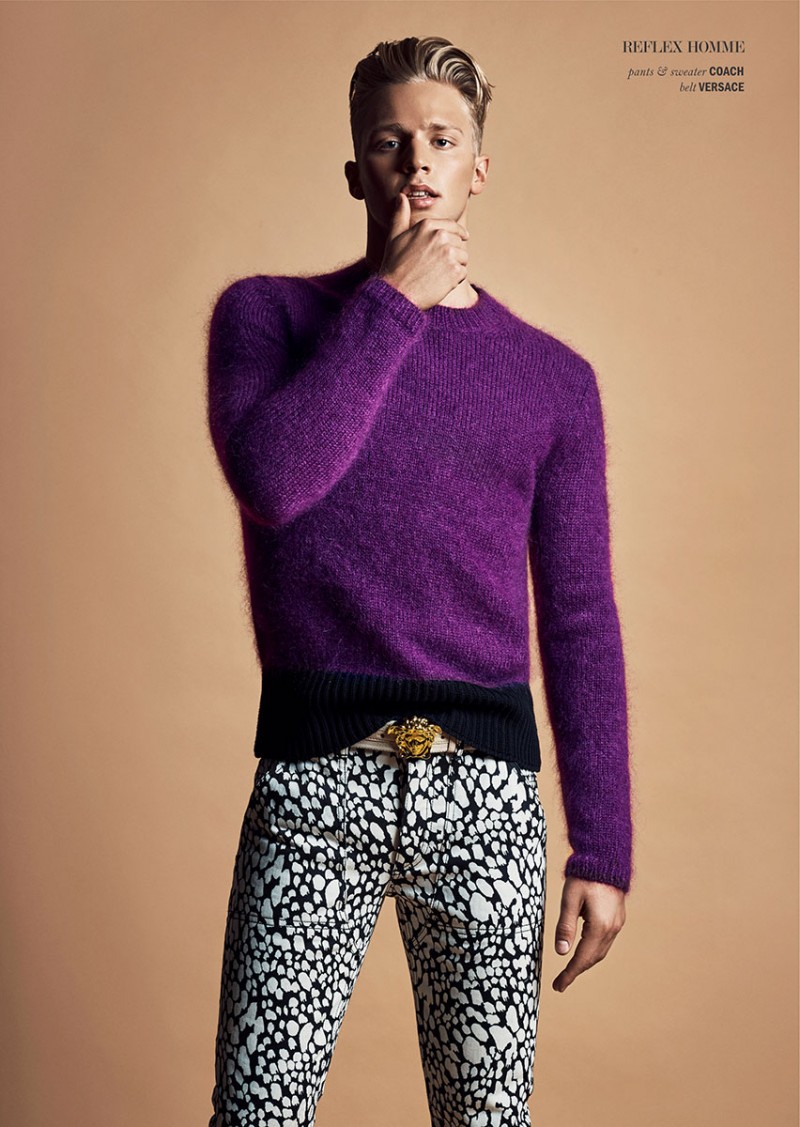 Clark Bockelman is a standout in a fitted crewneck sweater and printed pants from Coach, with a Versace belt.