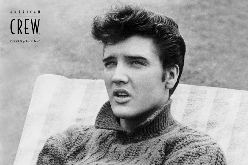 Elvis Presley captured in a casual photo, showing off a classic pompadour hairstyle.