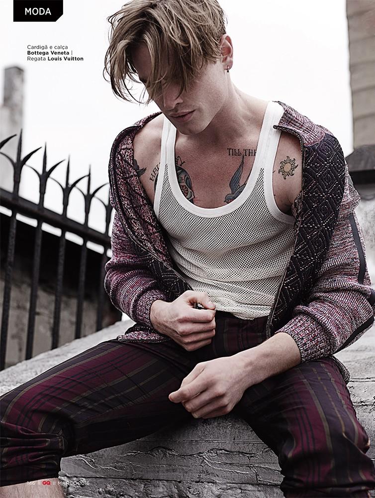 Patrick O'Donnell wears a Louis Vuitton mesh tank with a cardigan and striped pants from Bottega Veneta.