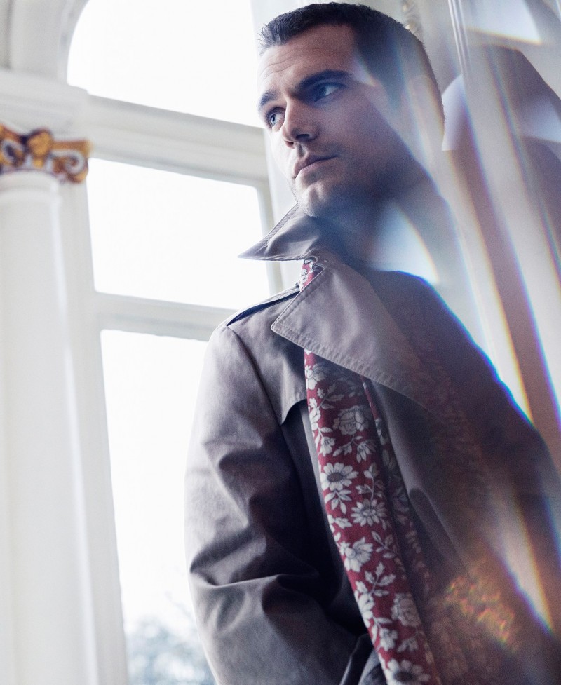 Henry Cavill sports a trench coat with a printed scarf for the pages of Sharp magazine.