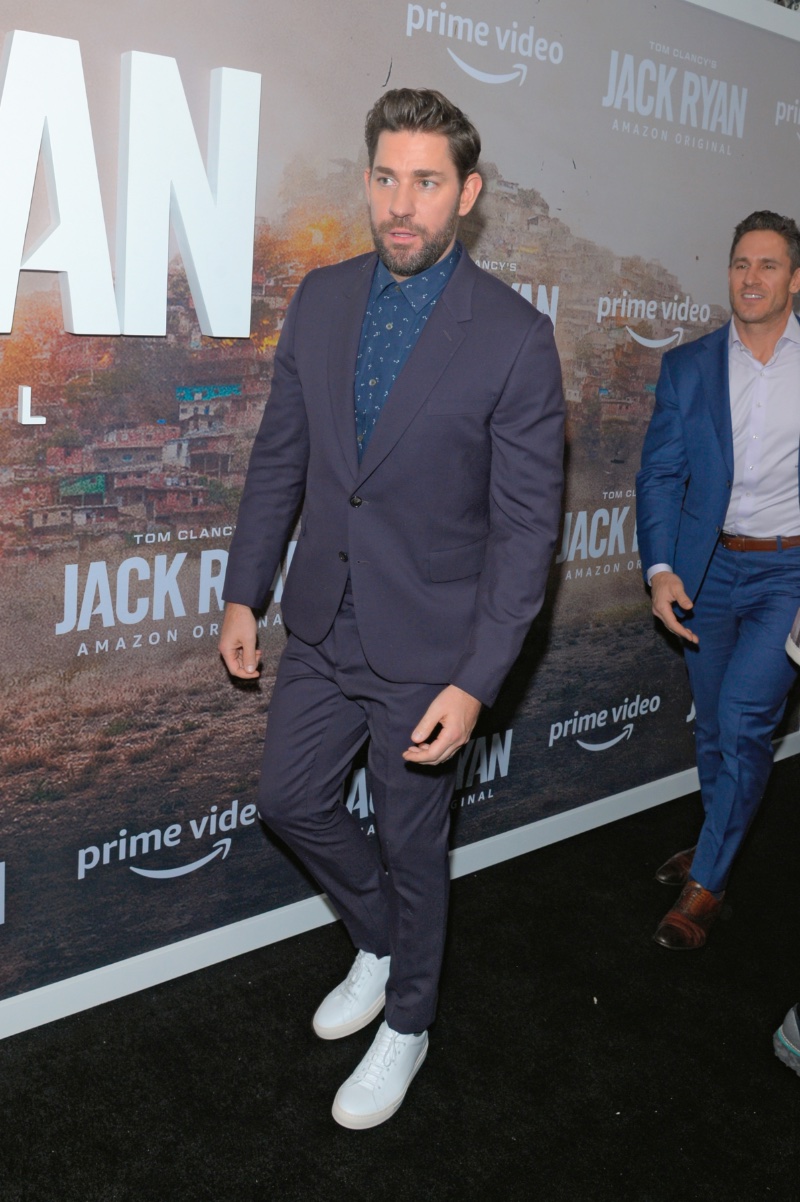 John Krasinski plays with a mix of blues as he dons a suit with white sneakers outfit for the Season Two Premiere of Tom Clancy's Jack Ryan in 2019.