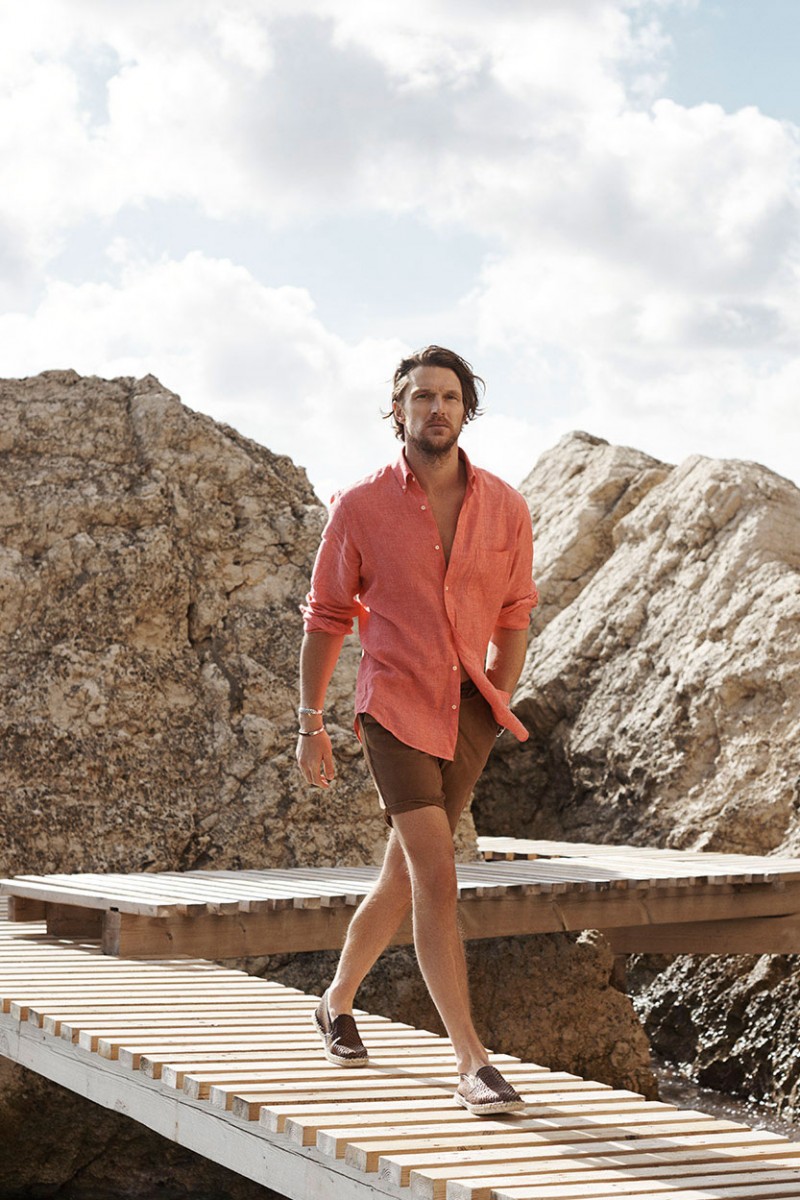 Shaun DeWet models a salmon colored shirt with brown shorts and espadrilles from Massimo Dutti.