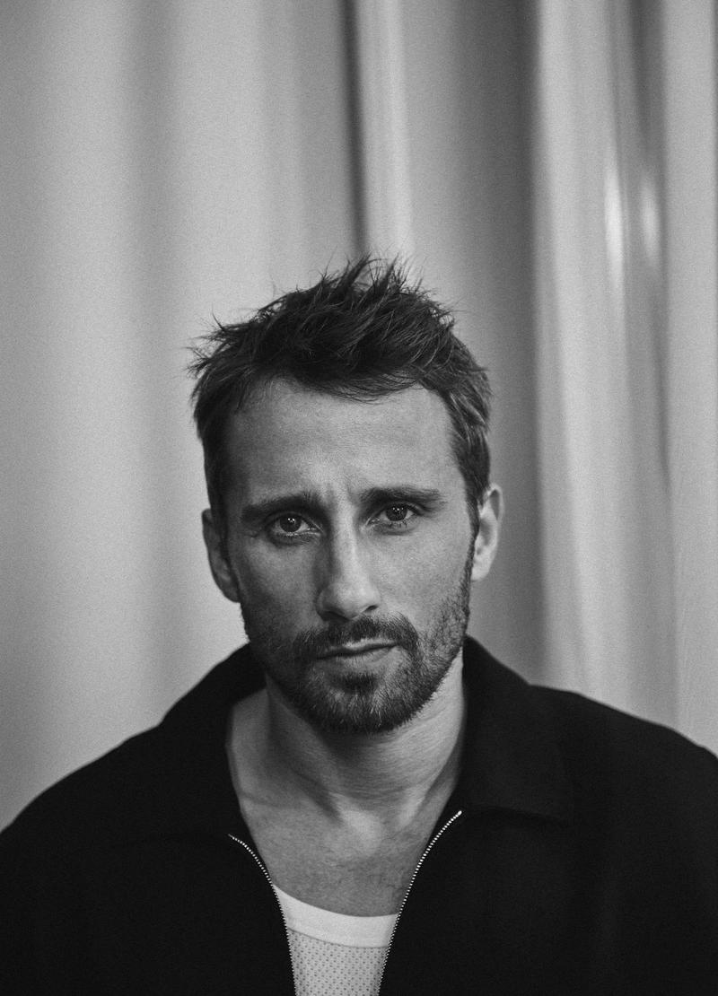 Matthias Schoenaerts poses for a black & white photo featured in the latest issue of L'Officiel Hommes Italia.