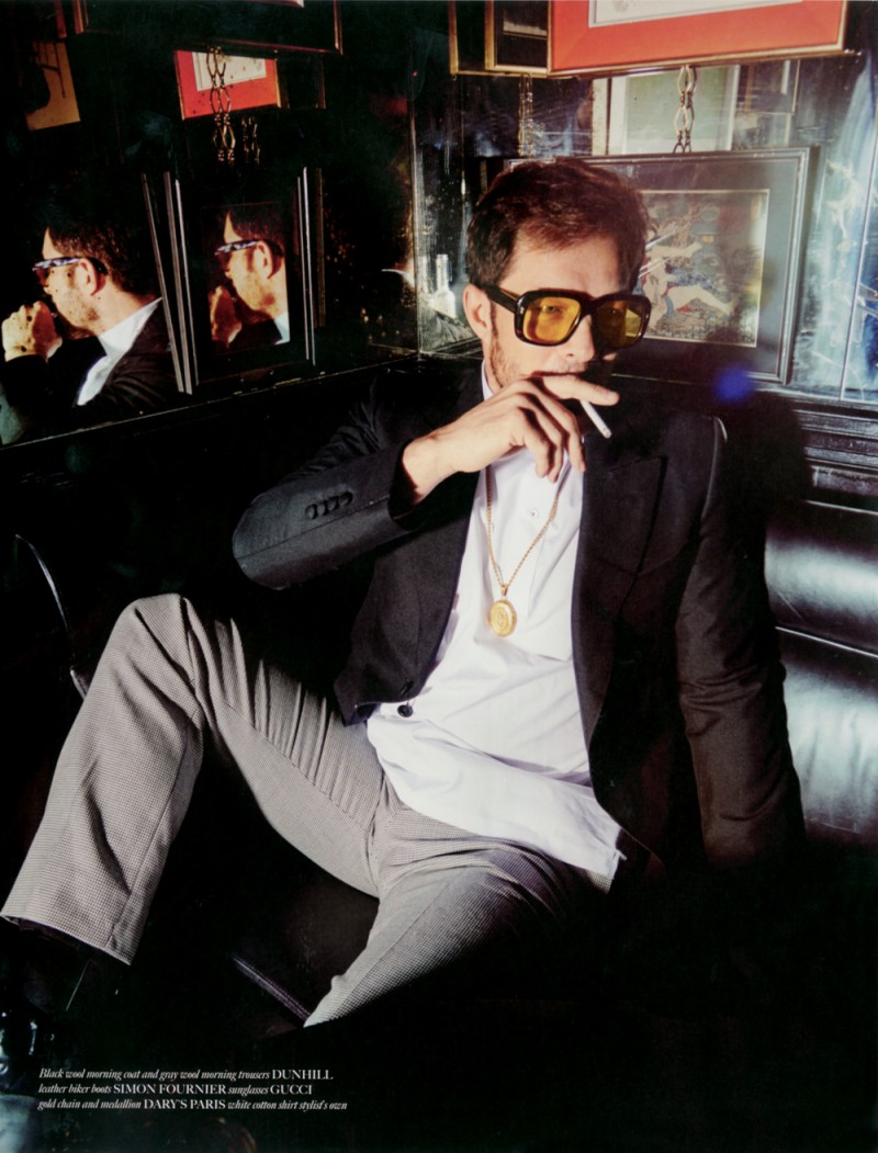 Sporting sunglasses from Gucci, Paul Sculfor relaxes in tailoring from Dunhill.