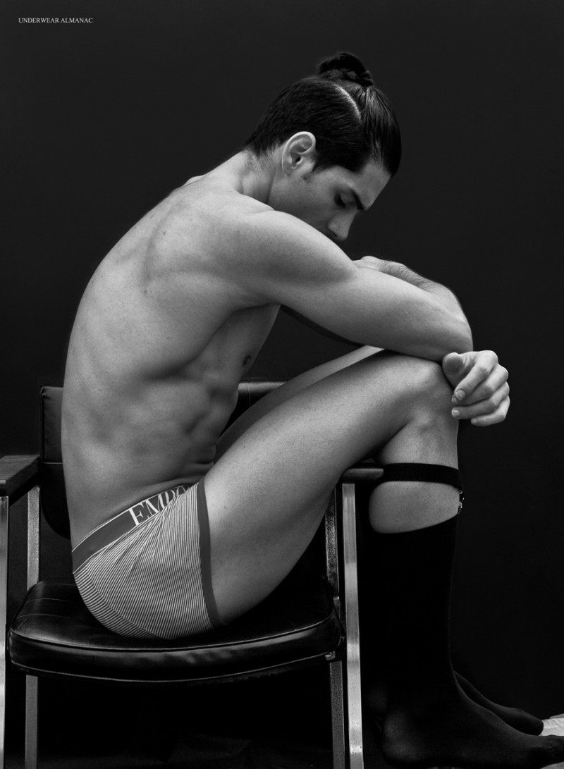 Taner Sigirtmac poses for a moody image in striped Emporio Armani underwear.