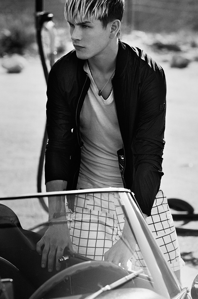 Luke Worrall sports a lightweight jacket, v-neck and grid print shorts for Armani Exchange's summer 2016 campaign.