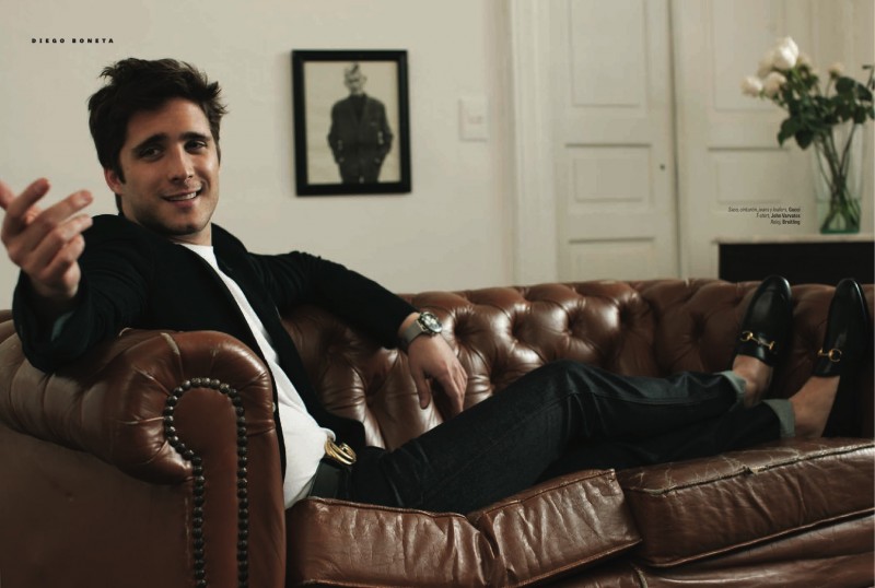 Diego Boneta relaxes on a leather sofa, wearing a look from Gucci, completed with a John Varvatos t-shirt.
