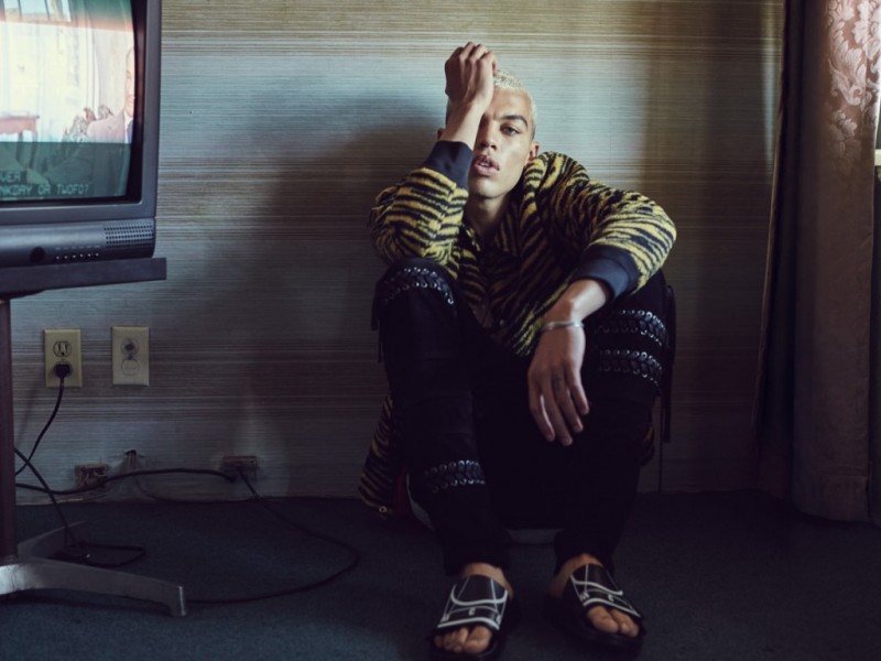 Dudley O'Shaughnessy rocks a Coach tiger print jacket with Diesel Black Gold pants and McQ Alexander McQueen slide sandals.