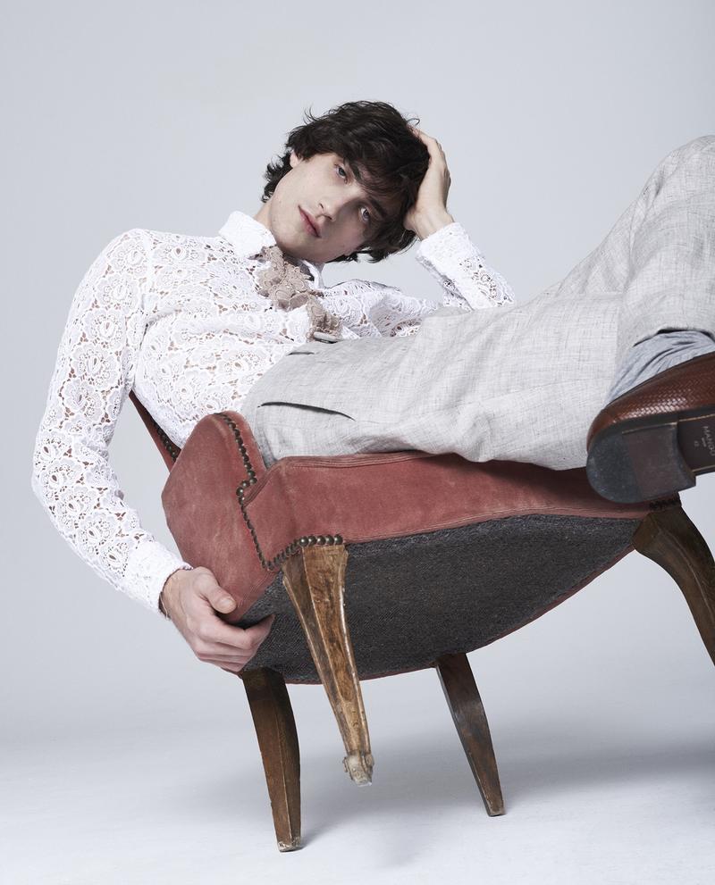 Lounging in a chair, Hamilton Seguin is pictured in a Burberry lace top with Hugo Boss trousers.