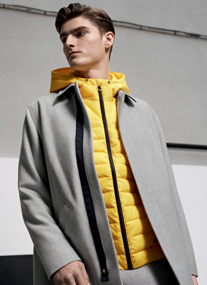 Alexander Beck is front and center in a light grey coat and yellow quilted jacket from Lacoste Live's fall-winter 2016 collection.