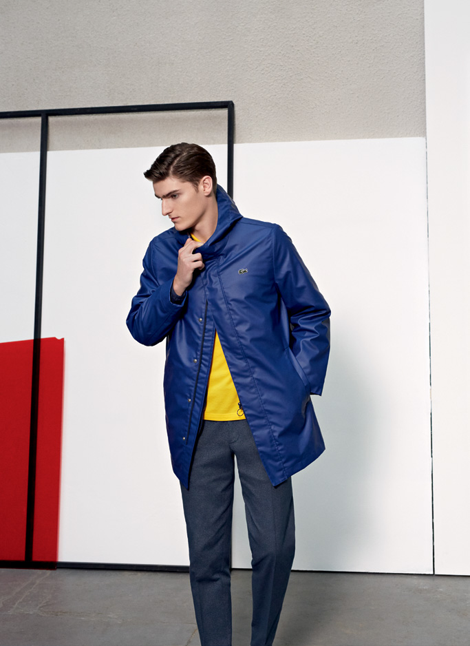 Alexander Beck embraces the fun but sporty spirit of Lacoste Live in a blue coat and bright yellow top.