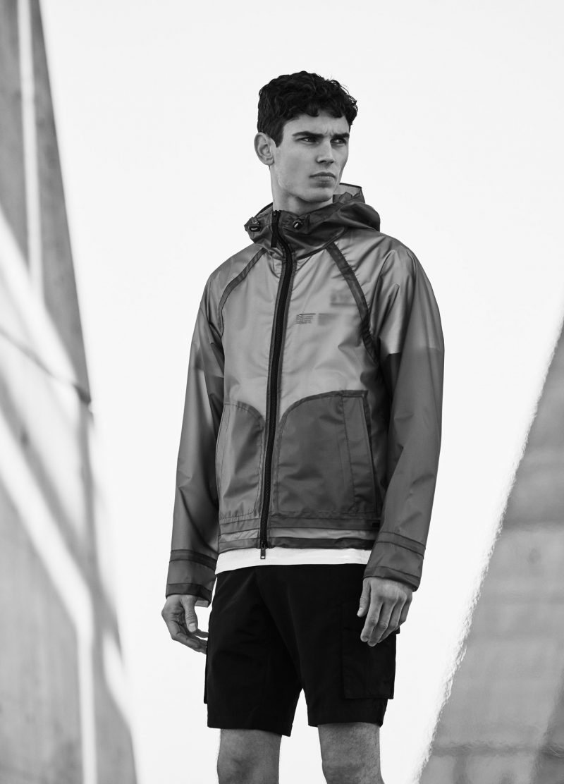 Arthur Gosse wears translucent jacket, graphic t-shirt and Bermuda shorts Mango.