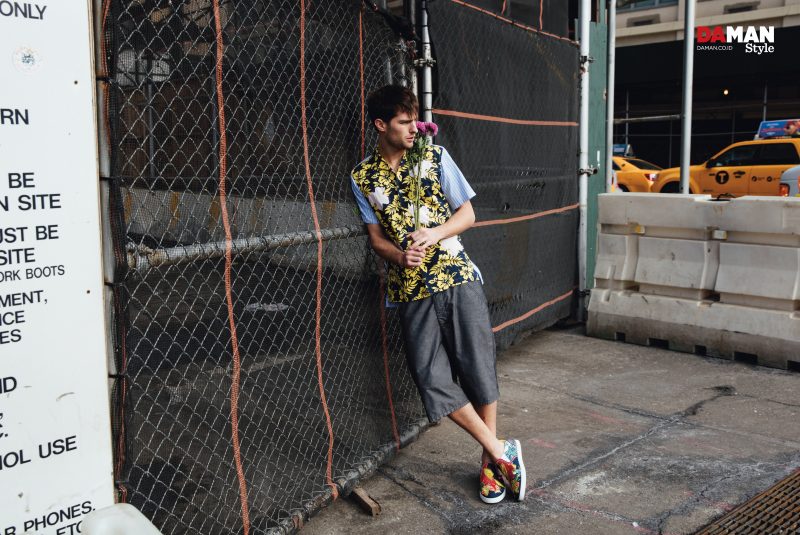 Paolo Anchisi captured in the streets of New York City, wearing a Comme des Garçons floral print short-sleeve shirt and oversized shorts with Christian Louboutin sneakers.