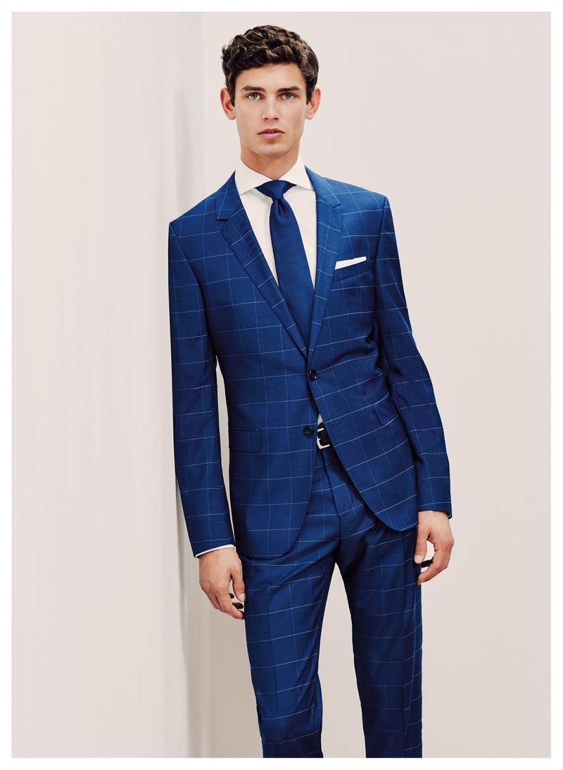 Arthur Gosse dons a blue windowpane suit from Tommy Hilfiger Tailored.