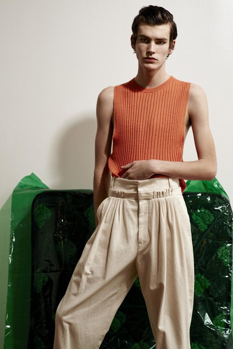 Elias de Poot cuts a lean figure in a sleeveless ribbed top from Acne Studios with a pleated J.W. Anderson trousers.