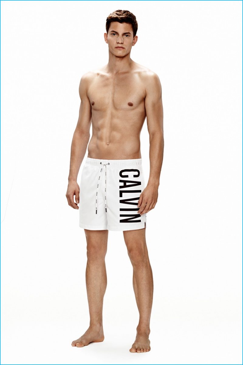 Benjamin Benedek models white Calvin Klein logo swim trunks.