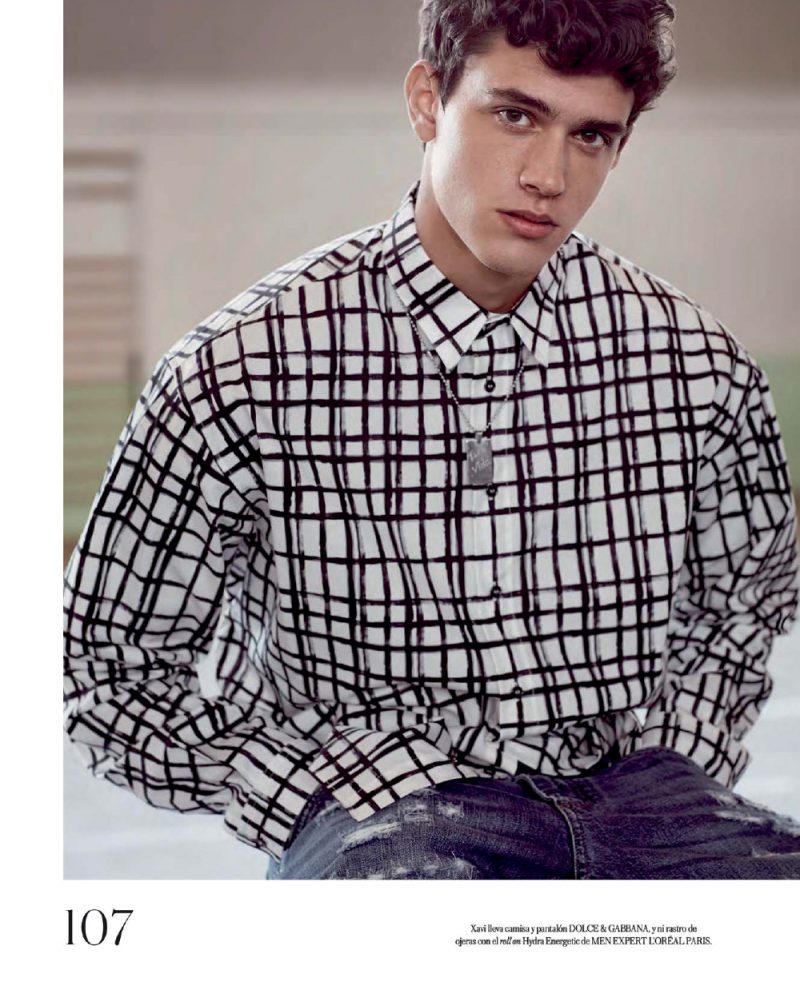 Xavier Serrano wears a graphic grid print shirt and denim jeans from Dolce & Gabbana.